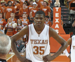 A basketball player, wearing a white jersey with the word «TEXAS» and the number 35 on the front, stands on a basketball court.